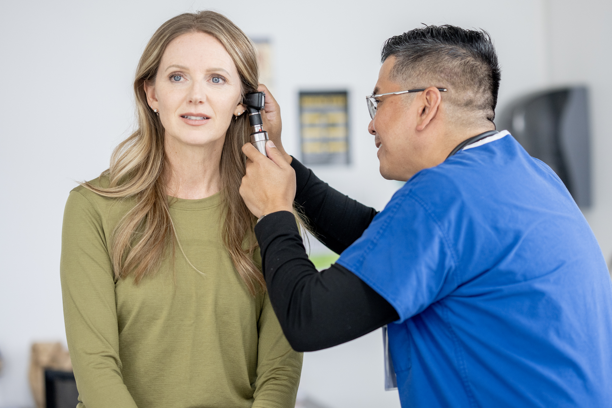 Woman in a shirt being examined by a doctor wearing a dress