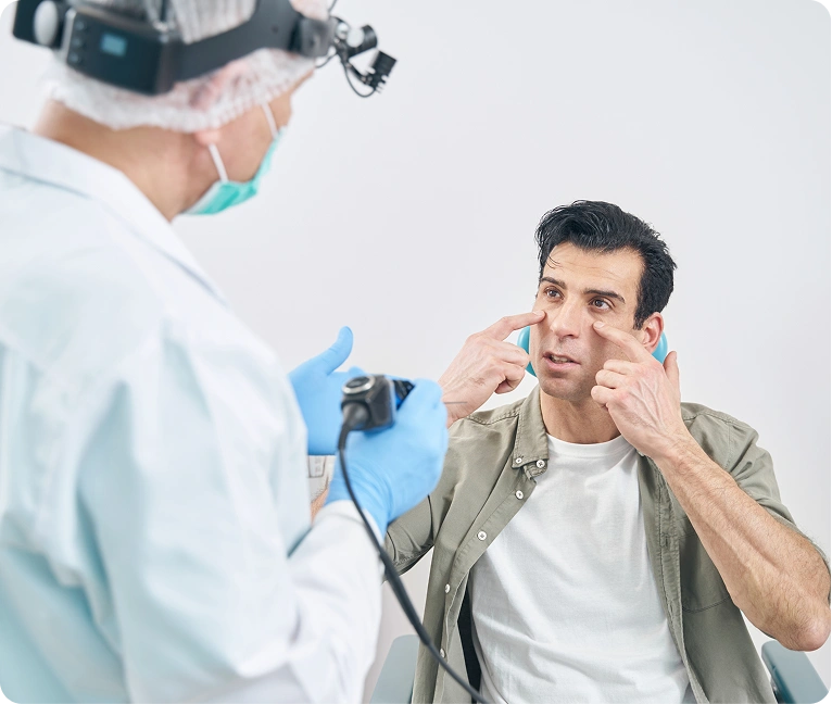 Man sitting in a chair with a doctor wearing a mask and gloves standing beside him