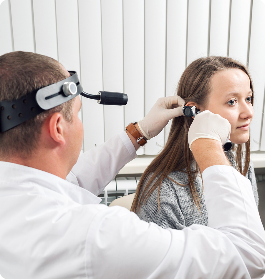 Woman getting her ear examined by a doctor wearing a coat and a watch