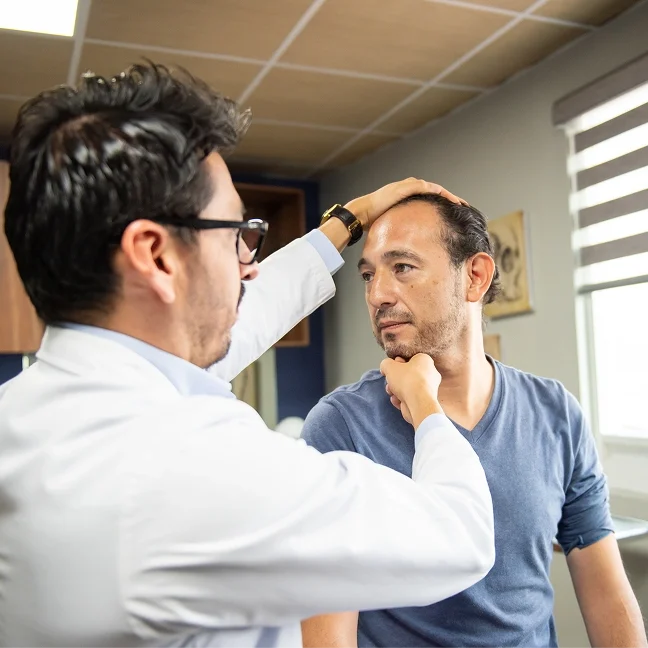 Man getting his hair cut by a doctor wearing glasses and a watch